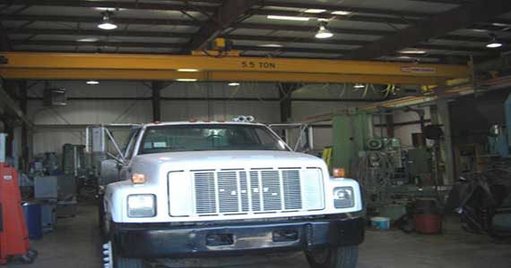 Service shop with multiple overhead doors, offices and a lit customer entry.