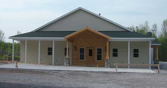 Steel building home with porch lean-to and residential window openings.